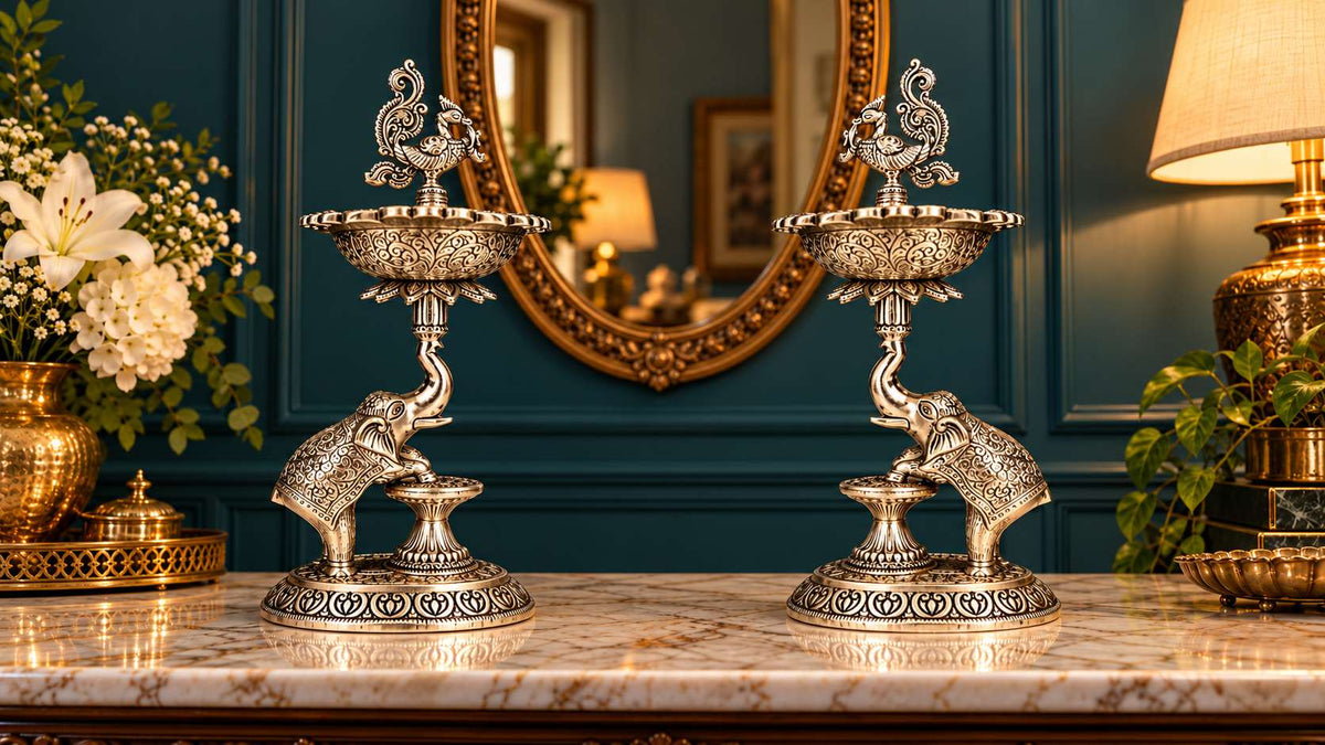Low angle view of plain German silver elephant samai lamps showing raised trunk and engraved bowl
