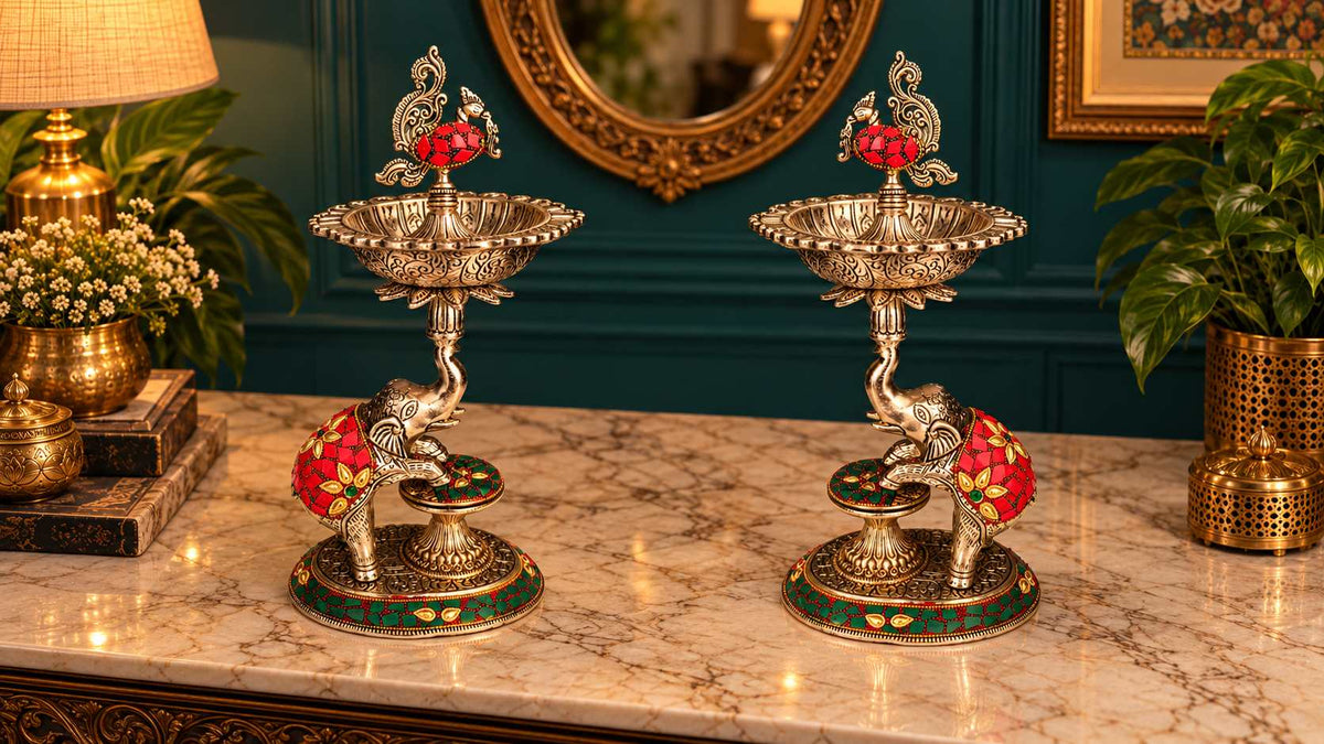 Elevated view of the samai lamp pair showing diya bowls, peacock finials and stonework bases