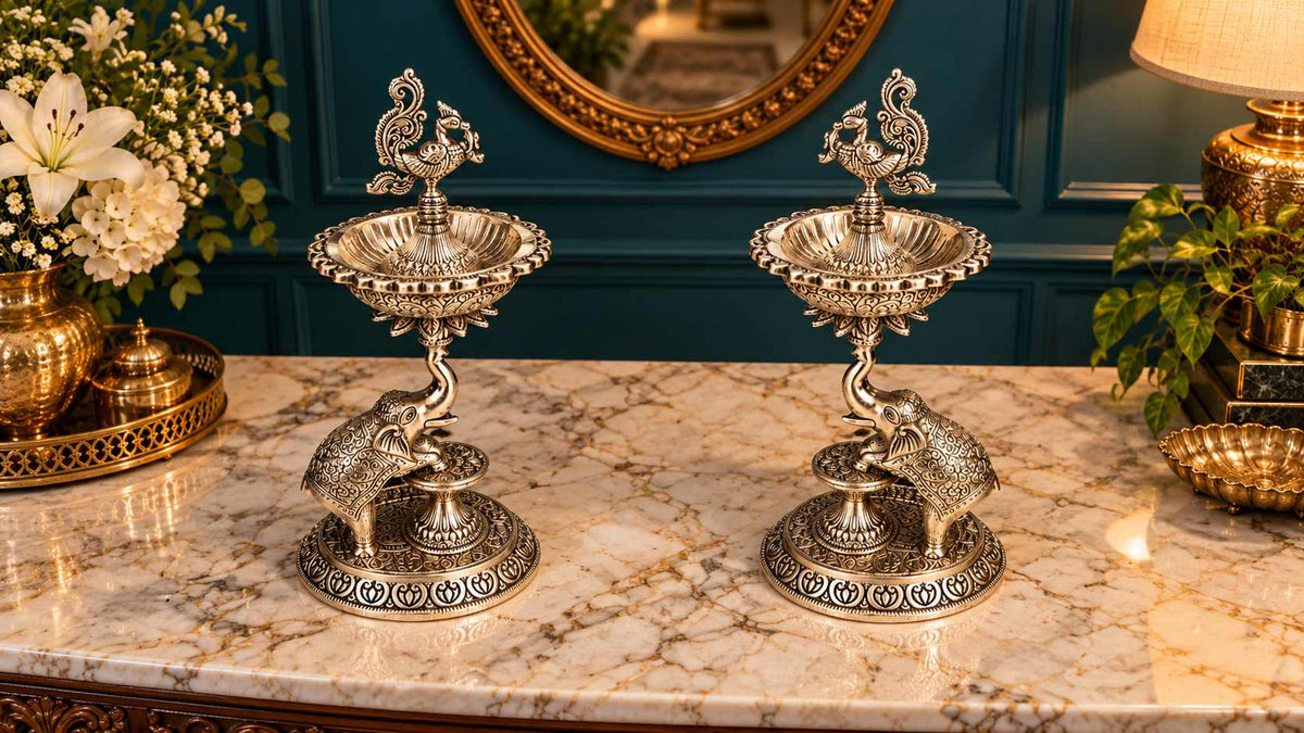 Elevated view of the samai lamp pair showing fluted diya bowls, peacock finials and engraved bases