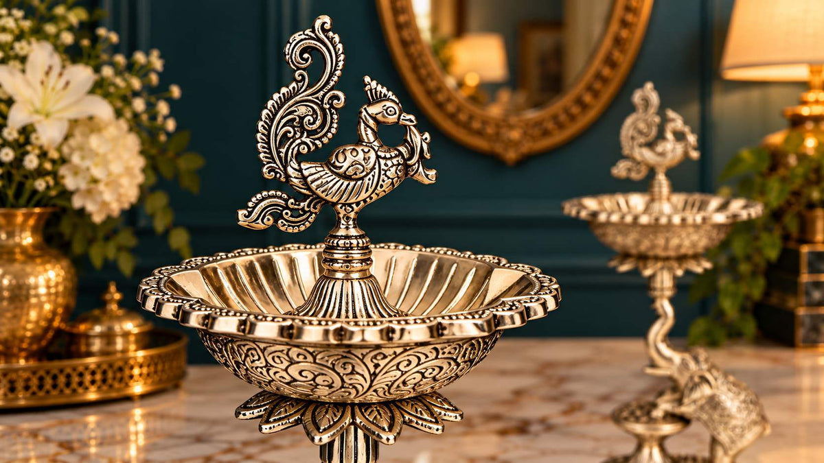 Close-up of engraved silver peacock finial and fluted diya bowl
